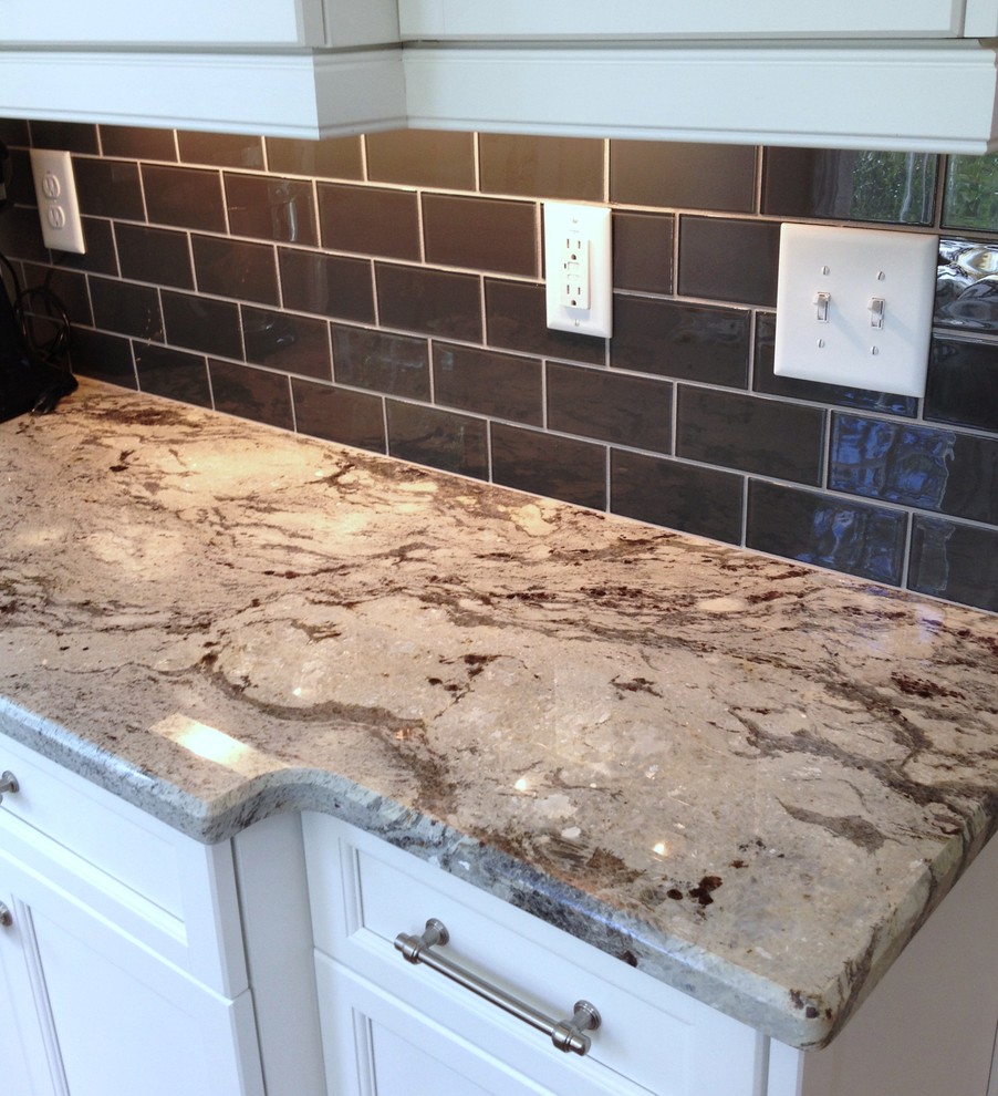 Eat-in kitchen - transitional galley medium tone wood floor eat-in kitchen idea in Raleigh with an undermount sink, shaker cabinets, white cabinets, granite countertops, gray backsplash, subway tile backsplash and stainless steel appliances