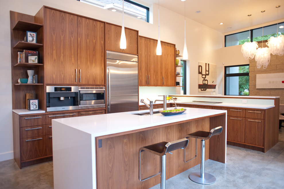 Photo of a modern l-shaped eat-in kitchen in Denver with an undermount sink, dark wood cabinets, quartz benchtops, blue splashback, glass sheet splashback and stainless steel appliances.