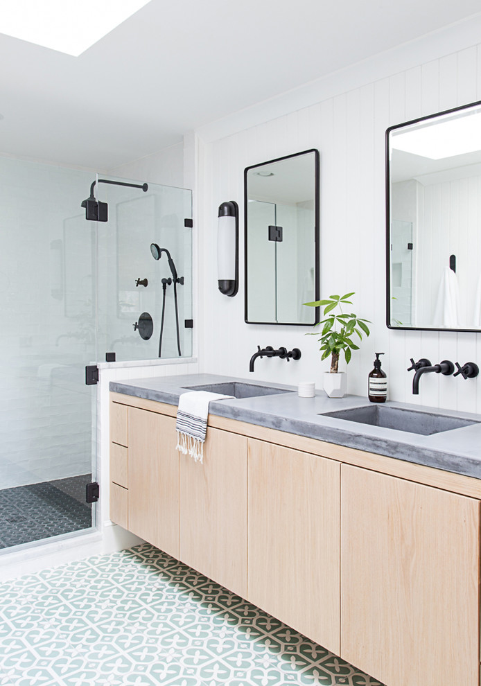 Design ideas for a mid-sized transitional master bathroom in New York with flat-panel cabinets, light wood cabinets, white tile, ceramic tile, white walls, cement tiles, an integrated sink, concrete benchtops, green floor, a hinged shower door and an alcove shower.