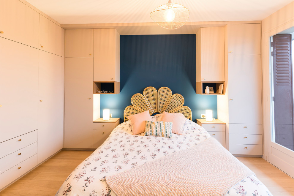 Diseño de dormitorio principal escandinavo pequeño sin chimenea con paredes azules y suelo de madera clara
