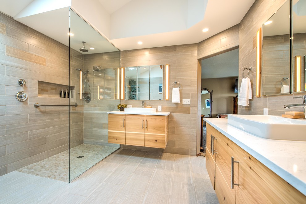 This is an example of a large modern master bathroom in Other with flat-panel cabinets, light wood cabinets, a freestanding tub, a curbless shower, a two-piece toilet, gray tile, ceramic tile, white walls, ceramic floors, a vessel sink, engineered quartz benchtops, grey floor and an open shower.