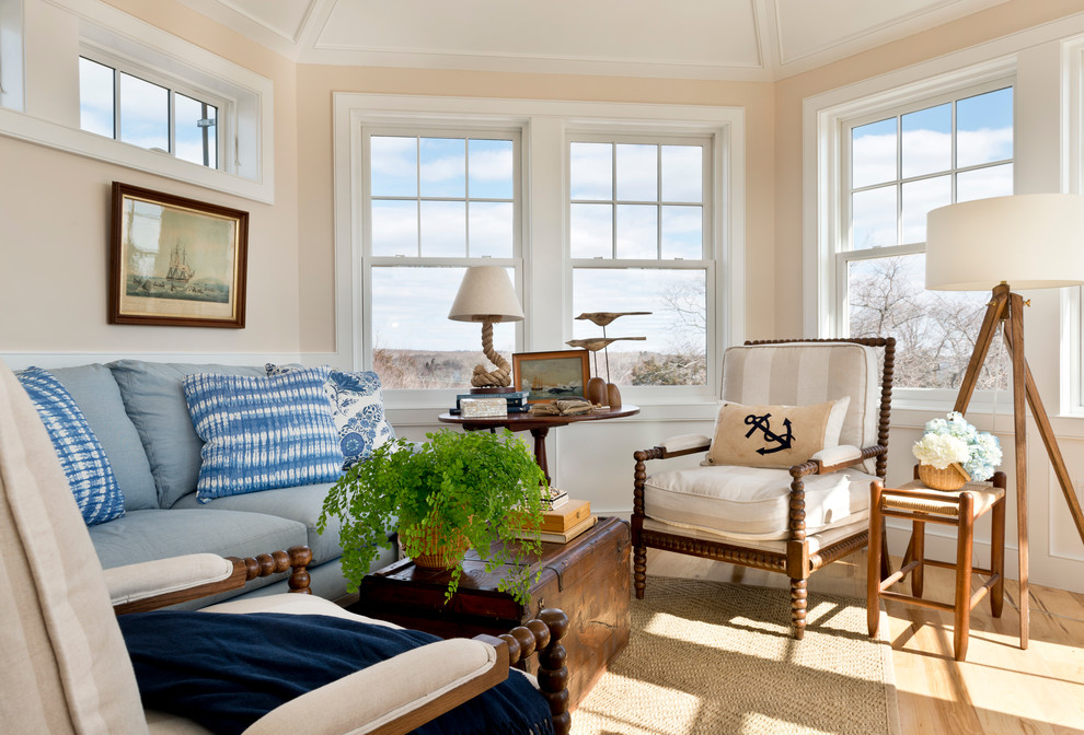 This is an example of a traditional family room in Providence with beige walls and light hardwood floors.