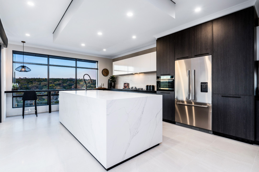 Photo of a large contemporary galley kitchen in Perth with an undermount sink, flat-panel cabinets, black cabinets, white splashback, stainless steel appliances, with island, white floor and black benchtop.
