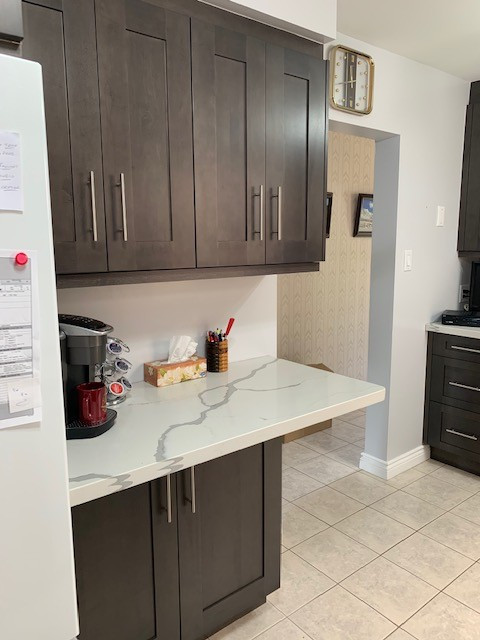 Inspiration for a mid-sized transitional terra-cotta tile and white floor enclosed kitchen remodel in Toronto with a double-bowl sink, recessed-panel cabinets, dark wood cabinets, quartz countertops, white backsplash, white appliances and no island