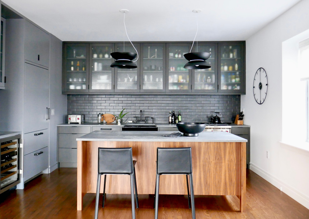 Idéer för ett stort klassiskt grå kök, med en rustik diskho, luckor med glaspanel, grå skåp, bänkskiva i kvarts, svart stänkskydd, stänkskydd i tegel, rostfria vitvaror, mellanmörkt trägolv, en köksö och brunt golv