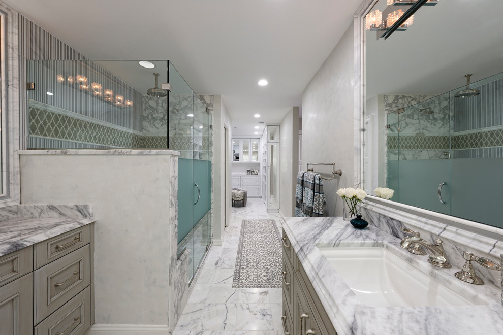 This is an example of a large transitional master bathroom in DC Metro with shaker cabinets, grey cabinets, a freestanding tub, a curbless shower, a bidet, gray tile, mosaic tile, grey walls, marble floors, an undermount sink, marble benchtops, white floor and an open shower.