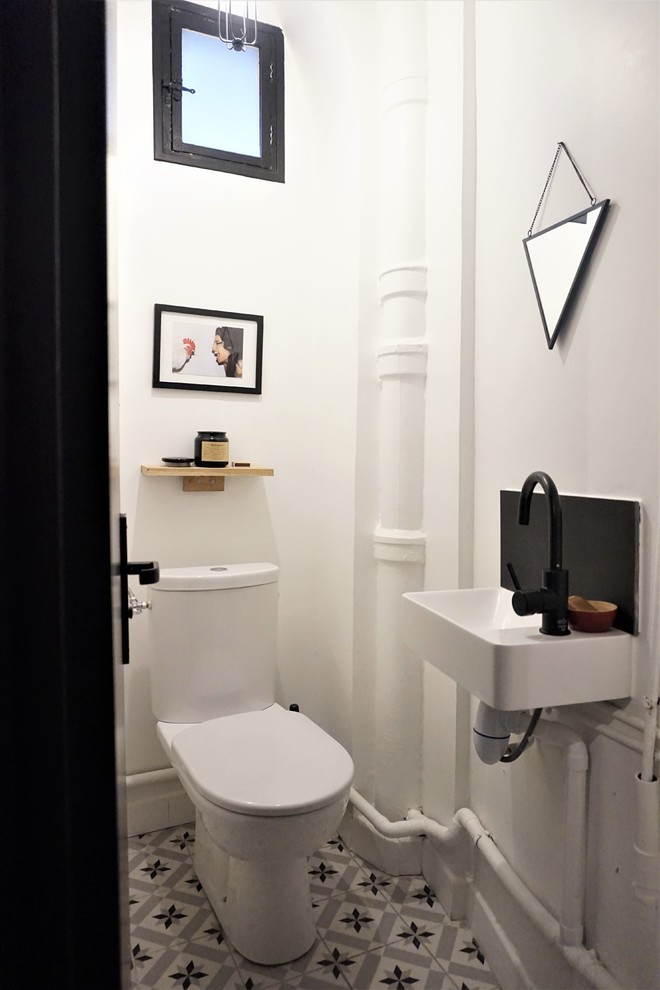Photo of a small contemporary powder room in Paris with white walls, a wall-mount sink and multi-coloured floor.