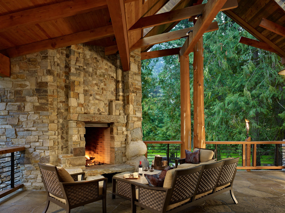 Country deck in Seattle with a fire feature and a roof extension.