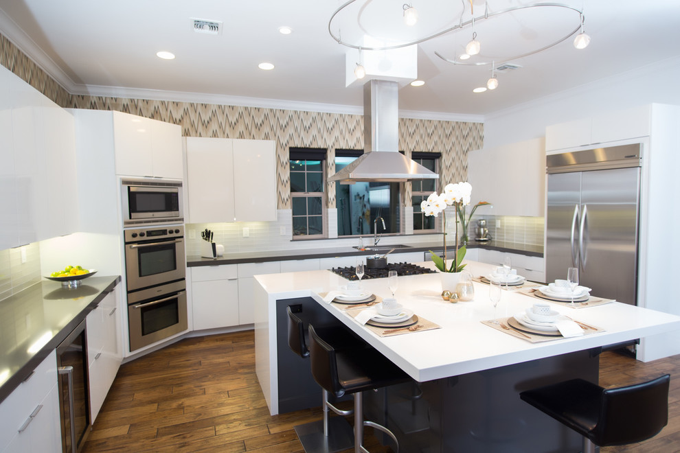 Design ideas for a modern kitchen in Sacramento with an undermount sink, flat-panel cabinets, white cabinets, solid surface benchtops, metallic splashback, glass tile splashback, stainless steel appliances and medium hardwood floors.