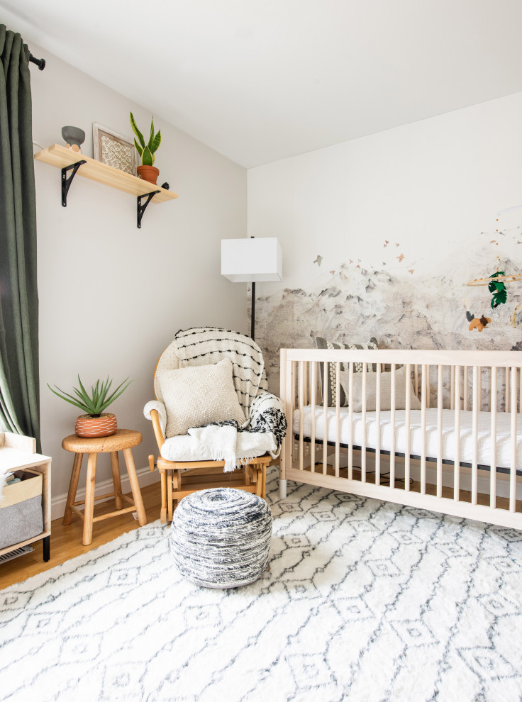 Idées déco pour une petite chambre de bébé neutre éclectique avec un mur beige, parquet clair et du papier peint.