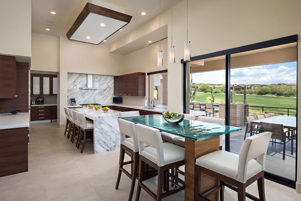 This is an example of a contemporary l-shaped eat-in kitchen in Phoenix with flat-panel cabinets, dark wood cabinets, multi-coloured splashback, white appliances, multiple islands and beige floor.