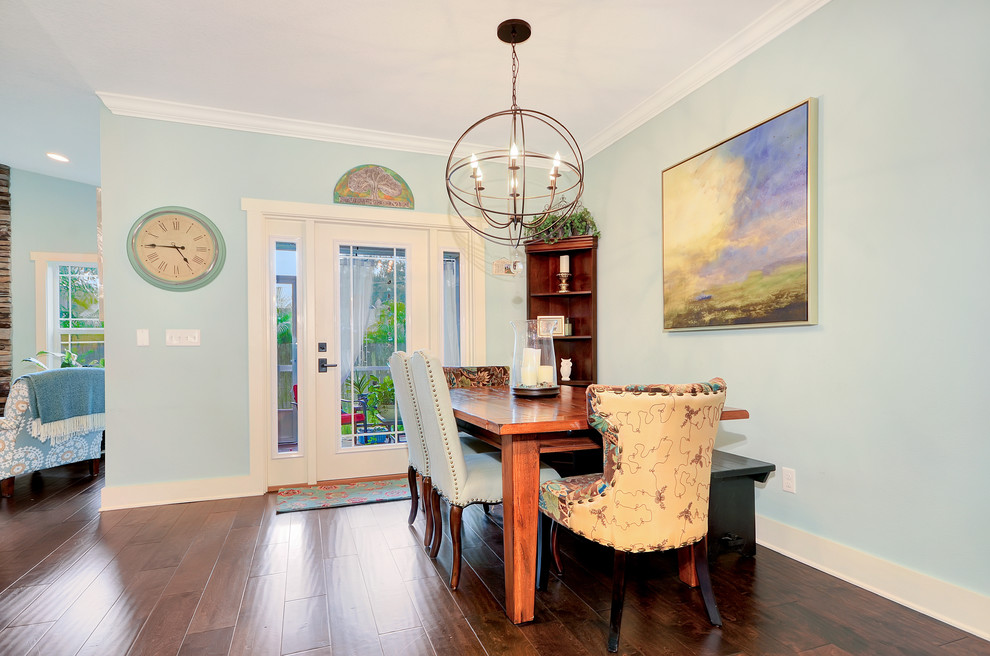 Photo of a small arts and crafts open plan dining in Tampa with blue walls, medium hardwood floors, a standard fireplace, a stone fireplace surround and brown floor.