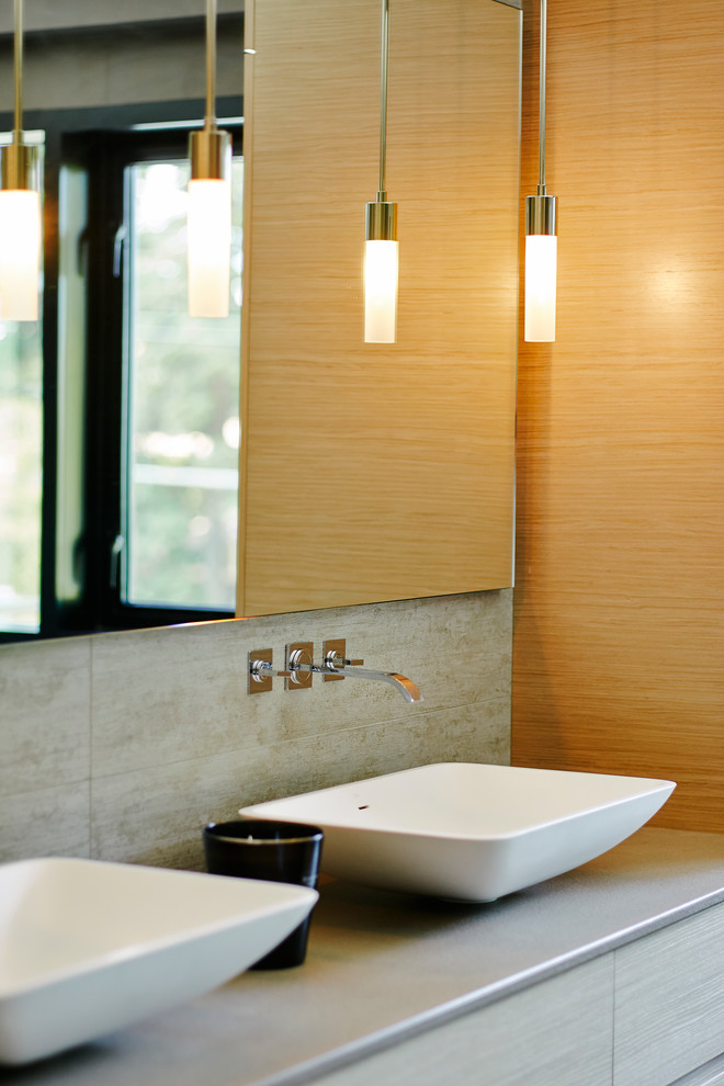 Inspiration for a mid-sized contemporary master bathroom in Vancouver with a vessel sink, flat-panel cabinets, light wood cabinets, engineered quartz benchtops, a freestanding tub, an open shower, a wall-mount toilet, gray tile, porcelain tile, grey walls and porcelain floors.