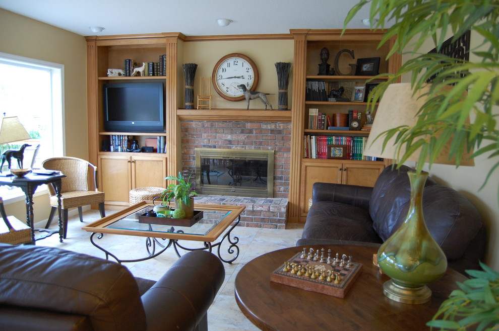 This is an example of a mid-sized traditional enclosed family room in Portland with yellow walls, a standard fireplace, a brick fireplace surround, a built-in media wall, ceramic floors and beige floor.