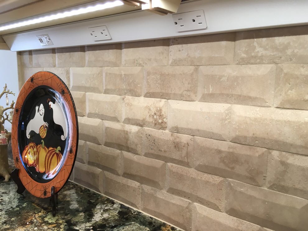 Example of a large transitional galley porcelain tile enclosed kitchen design with an undermount sink, raised-panel cabinets, distressed cabinets, granite countertops, beige backsplash, stone tile backsplash, stainless steel appliances and a peninsula