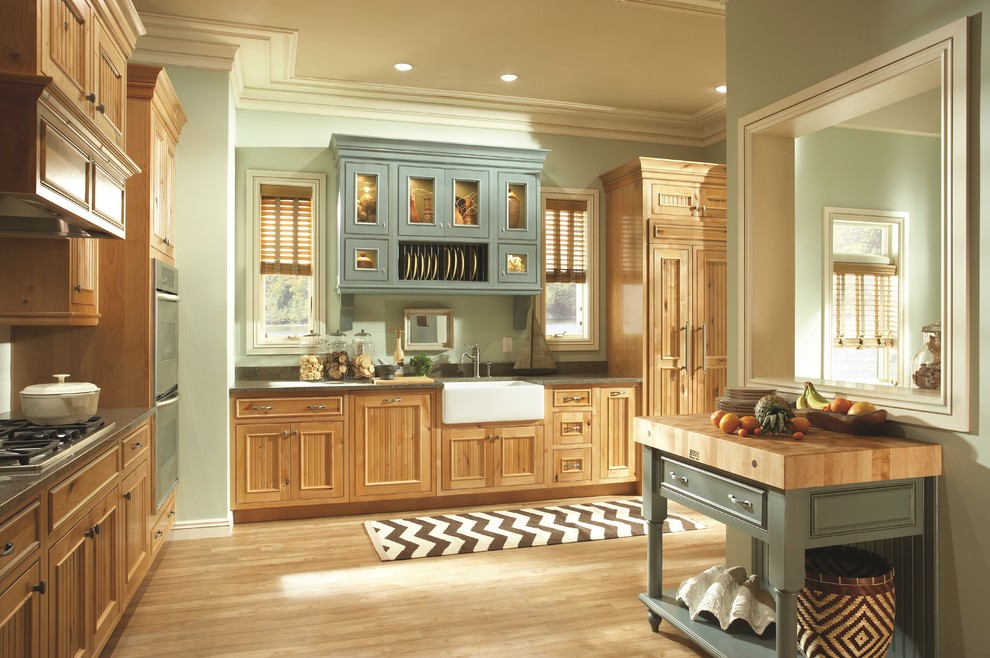 Design ideas for a large country l-shaped separate kitchen in Chicago with a farmhouse sink, louvered cabinets, light wood cabinets, green splashback, stainless steel appliances, light hardwood floors and no island.