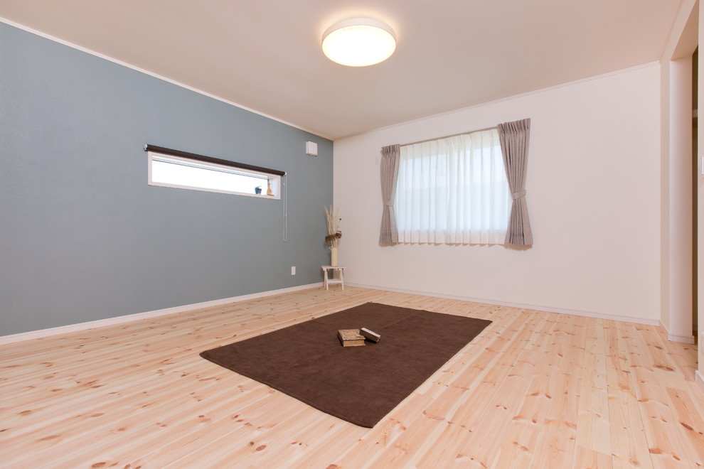 This is an example of a scandinavian master bedroom in Other with blue walls and light hardwood flooring.