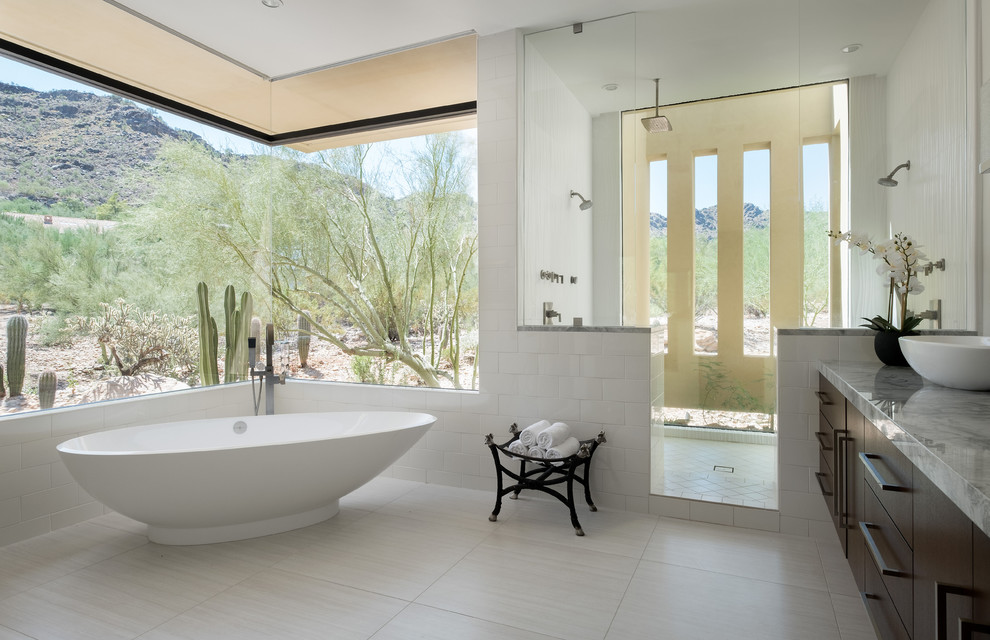 Master bathroom in Phoenix with flat-panel cabinets, dark wood cabinets, a freestanding tub, an alcove shower, white tile, white walls, a vessel sink, white floor and an open shower.