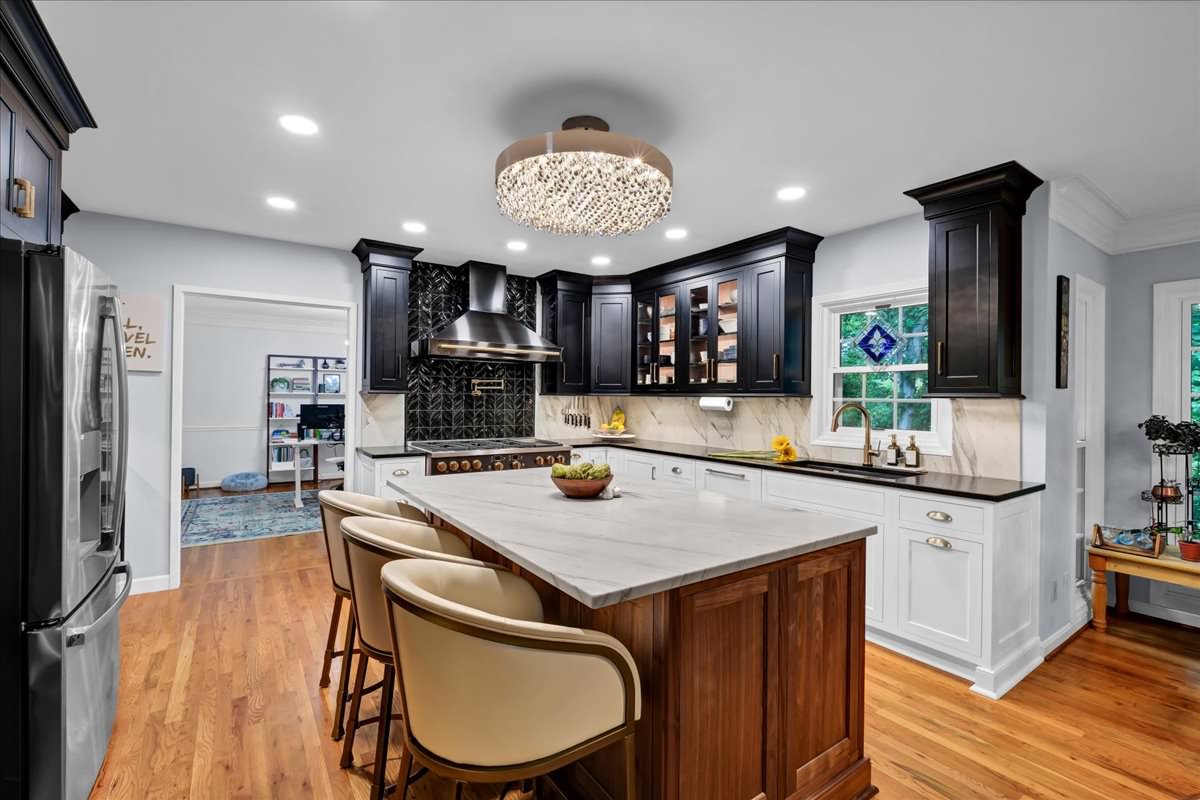 With 5 children, the homeowners need a professional grade kitchen with ample storage and special touches like a stand mixer lift.  The walnut island was expanded and the tuxedo perimeter cabinets were