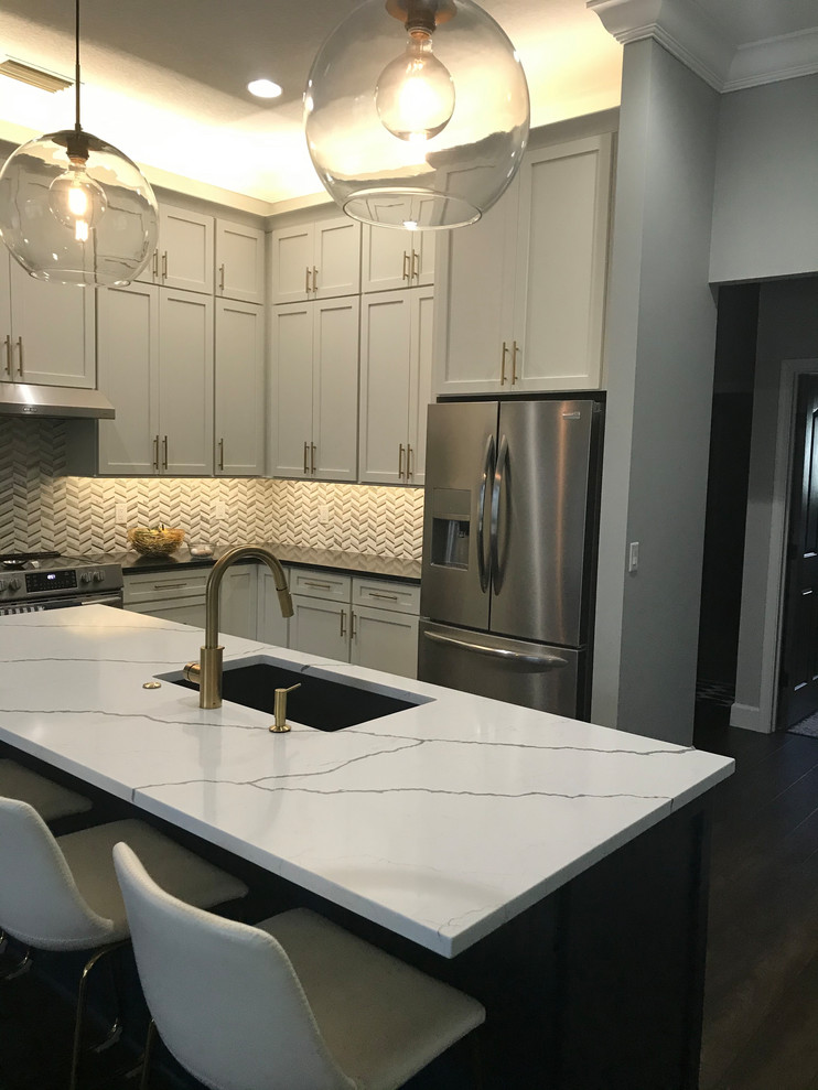 Inspiration for a huge transitional l-shaped vinyl floor and brown floor open concept kitchen remodel in Baltimore with an undermount sink, shaker cabinets, white cabinets, quartz countertops, white backsplash, marble backsplash, stainless steel appliances, an island and multicolored countertops
