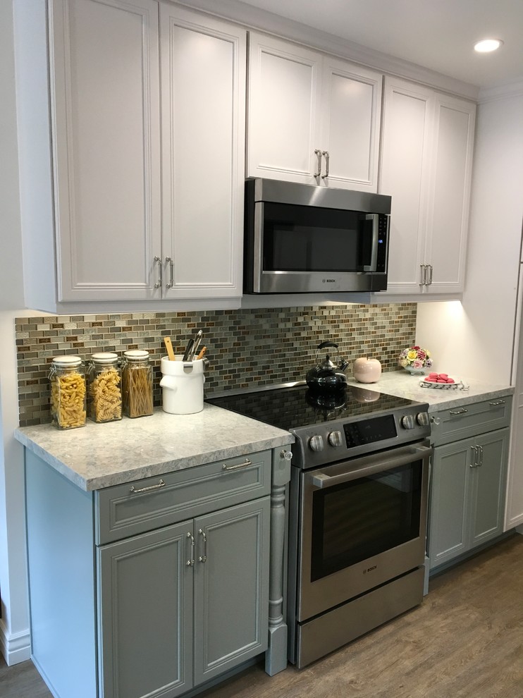This is an example of a mid-sized transitional galley eat-in kitchen in San Diego with a double-bowl sink, recessed-panel cabinets, blue cabinets, multi-coloured splashback, mosaic tile splashback, stainless steel appliances, vinyl floors and no island.