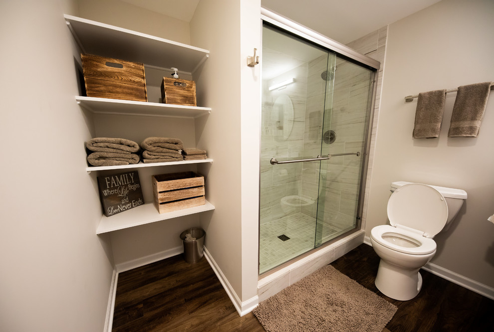 Mid-sized transitional 3/4 gray tile and porcelain tile dark wood floor and brown floor alcove shower photo in Chicago with raised-panel cabinets, dark wood cabinets, a two-piece toilet, beige walls, an integrated sink, solid surface countertops and white countertops