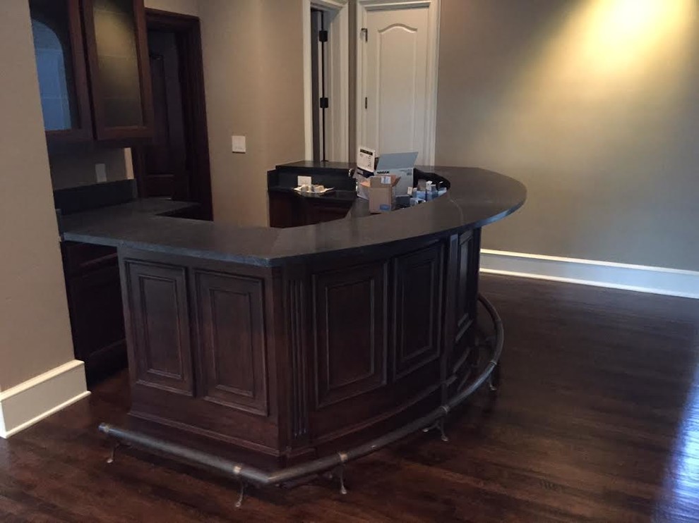 Design ideas for a mid-sized traditional single-wall seated home bar in Dallas with recessed-panel cabinets, dark wood cabinets and medium hardwood floors.