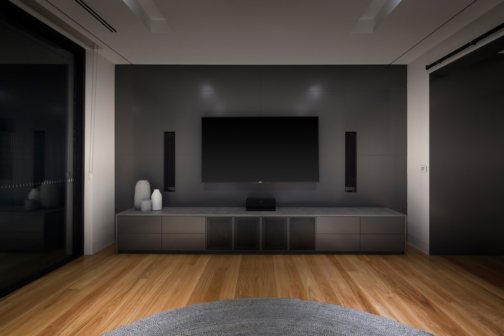 Inspiration for a large contemporary home theatre in Canberra - Queanbeyan with light hardwood floors and a wall-mounted tv.