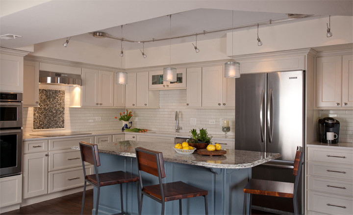Example of a mid-sized transitional l-shaped dark wood floor eat-in kitchen design in Chicago with an undermount sink, recessed-panel cabinets, white cabinets, quartz countertops, white backsplash, subway tile backsplash, stainless steel appliances, gray walls and an island