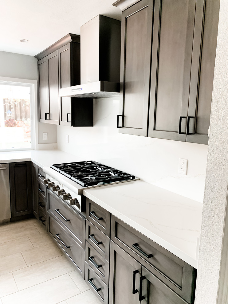 Foto på ett mellanstort funkis vit u-kök, med en rustik diskho, skåp i shakerstil, grå skåp, bänkskiva i kvarts, vitt stänkskydd, rostfria vitvaror, klinkergolv i porslin, en halv köksö och beiget golv