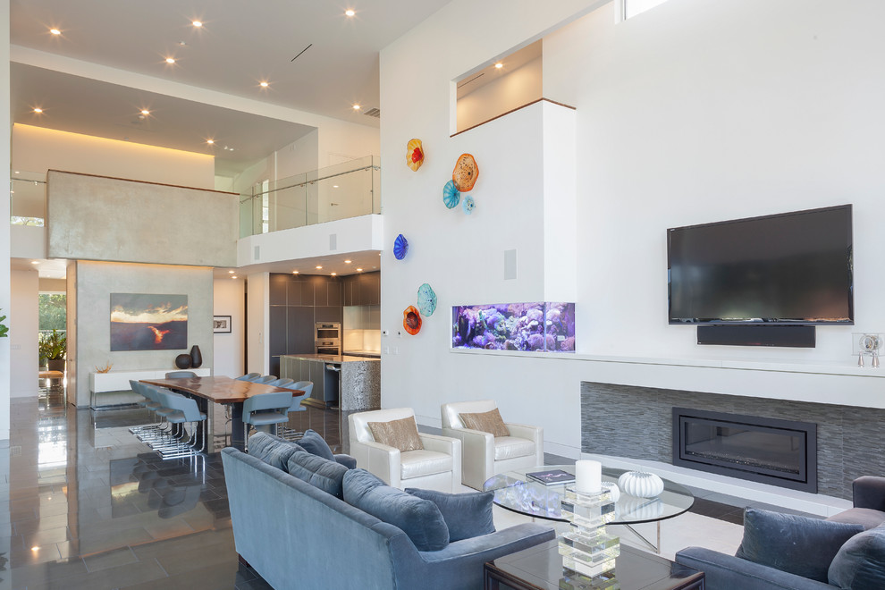 Large modern open concept living room in Houston with white walls, ceramic floors, a standard fireplace, a stone fireplace surround and a wall-mounted tv.