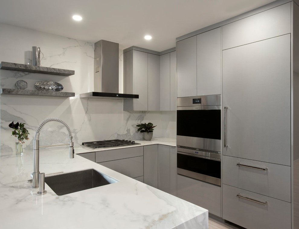 Small contemporary u-shaped kitchen in Boston with an undermount sink, flat-panel cabinets, grey cabinets, solid surface benchtops, white splashback, marble splashback, stainless steel appliances, bamboo floors, a peninsula, beige floor and white benchtop.