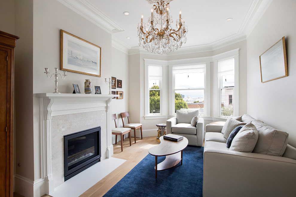 Photo of a large transitional enclosed living room in San Francisco with beige walls, light hardwood floors, a standard fireplace, a tile fireplace surround and no tv.