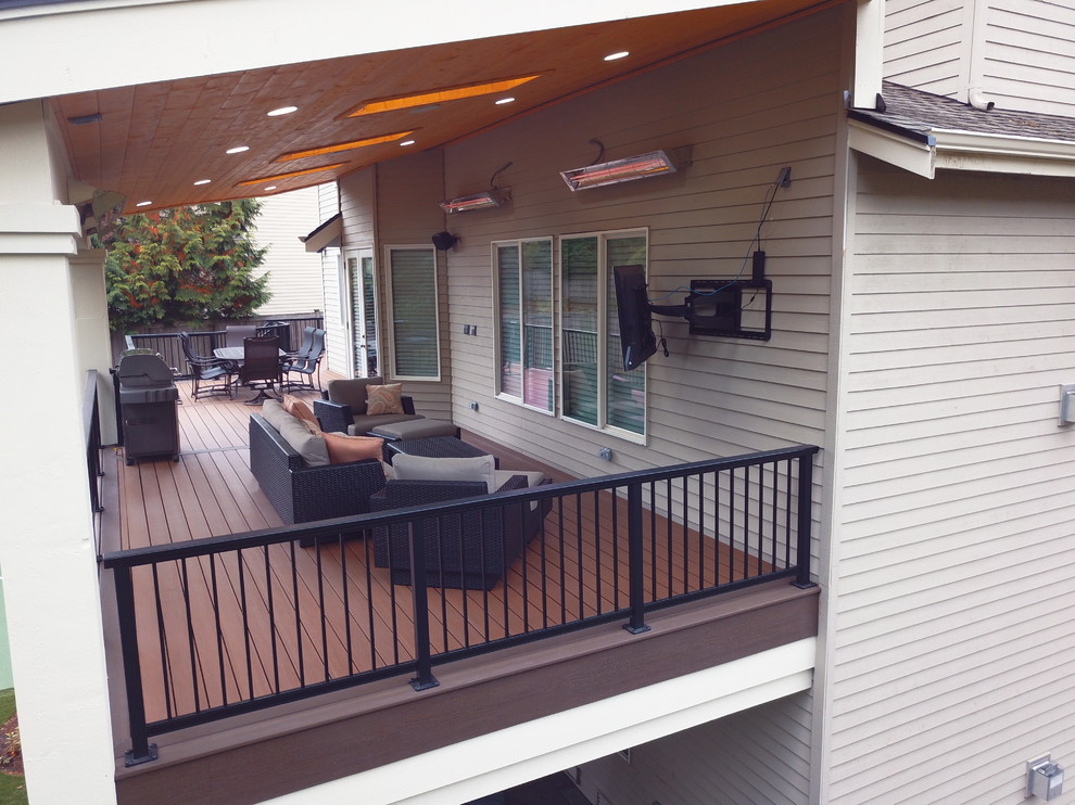Inspiration for a huge modern backyard concrete paver partial sun deck remodel for summer in Seattle with a fire pit and a roof extension