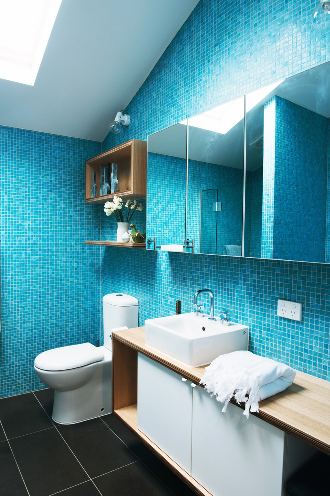 Inspiration for a large contemporary master bathroom in Melbourne with a vessel sink, flat-panel cabinets, white cabinets, wood benchtops, a two-piece toilet, blue tile, mosaic tile and ceramic floors.