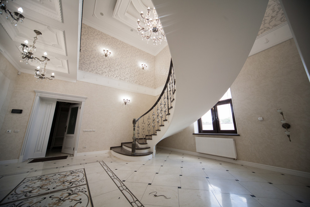 Бетонная лестница со ступенями из дуба и кованными балясинаями