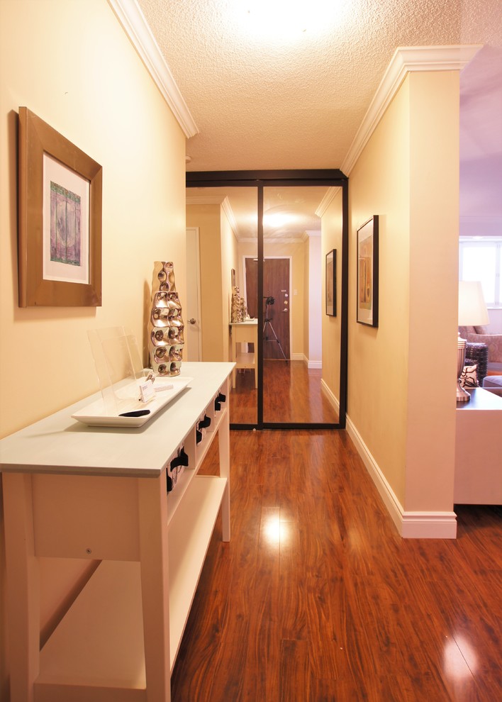 Example of a small transitional vinyl floor foyer design in Toronto with beige walls and a medium wood front door