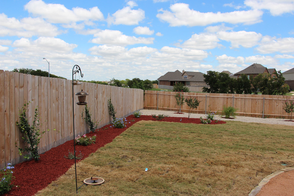 This is an example of a mid-sized transitional full sun backyard gravel garden path in Austin for summer.