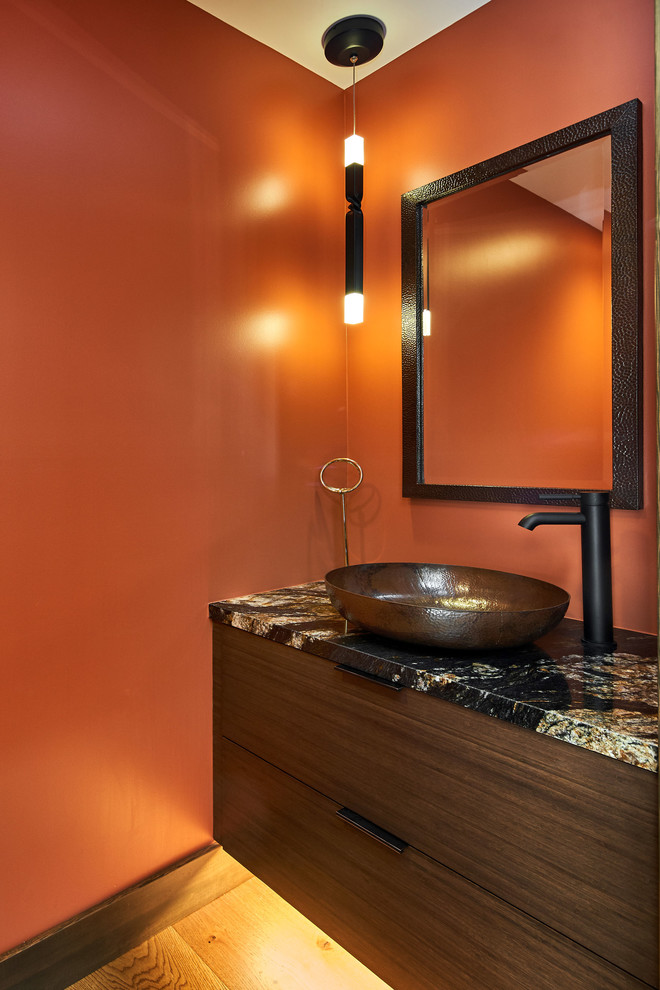 Design ideas for a small transitional powder room in San Francisco with flat-panel cabinets, dark wood cabinets, red walls, medium hardwood floors, a vessel sink, granite benchtops and black benchtops.