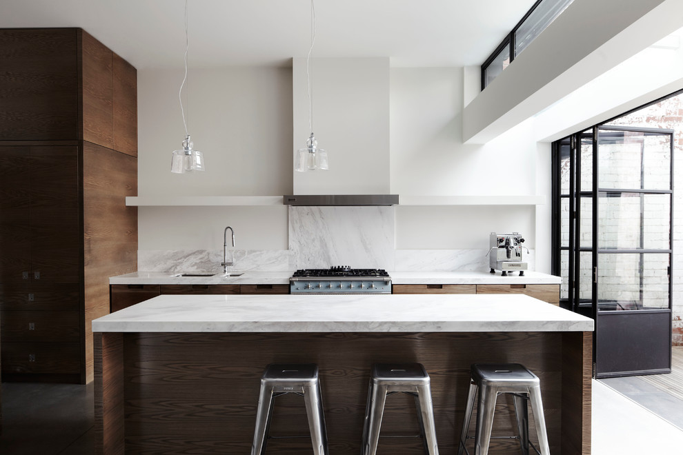 This is an example of a mid-sized contemporary kitchen in Melbourne with an undermount sink, flat-panel cabinets, medium wood cabinets, marble benchtops, white splashback, stone slab splashback and with island.