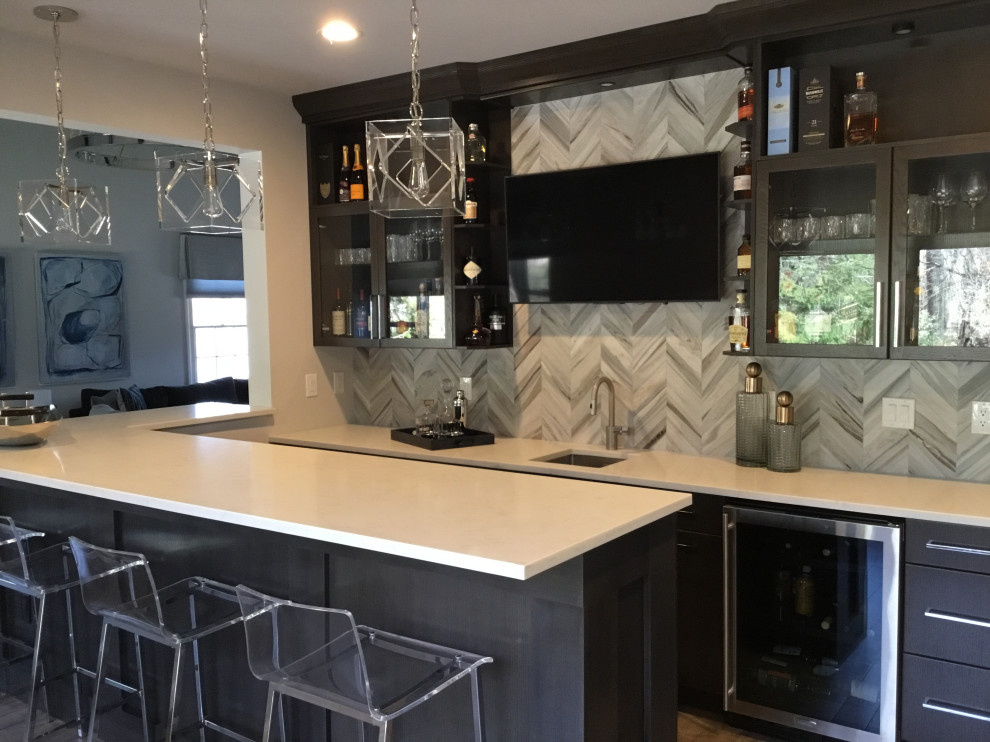 Inspiration for a large modern l-shaped seated home bar in New York with an undermount sink, flat-panel cabinets, dark wood cabinets, quartz benchtops, grey splashback, marble splashback, painted wood floors, grey floor and white benchtop.