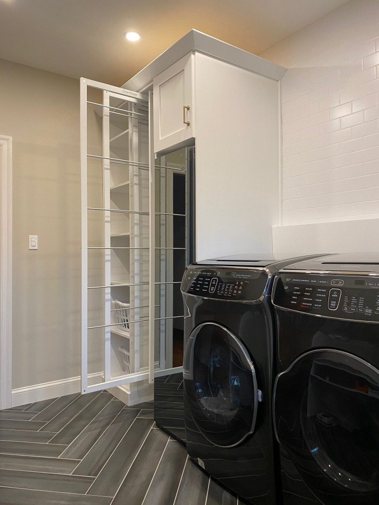 Design ideas for a mid-sized transitional galley dedicated laundry room in Other with a farmhouse sink, flat-panel cabinets, white cabinets, quartz benchtops, beige walls, ceramic floors, a side-by-side washer and dryer, brown floor and white benchtop.