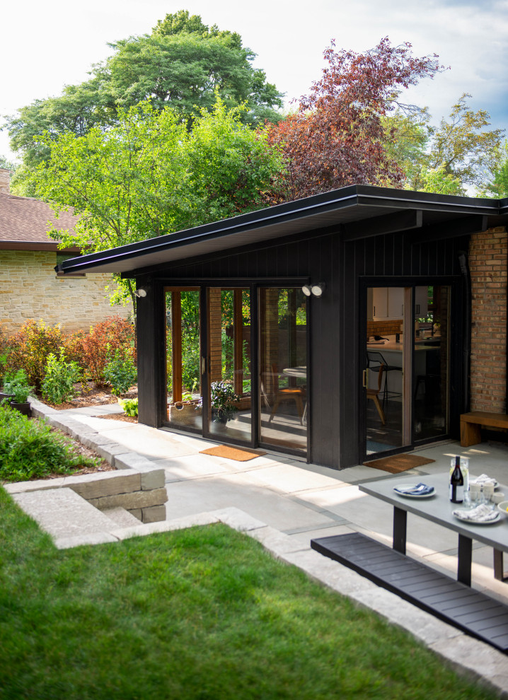 Esempio di un patio o portico moderno di medie dimensioni e dietro casa con lastre di cemento