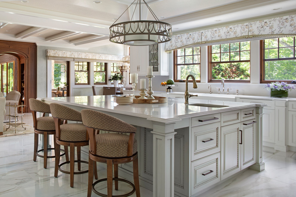 This is an example of a large traditional kitchen in New York with a farmhouse sink, raised-panel cabinets, white cabinets, quartzite benchtops, white splashback, stone slab splashback, stainless steel appliances, ceramic floors, with island, white floor, white benchtop and coffered.