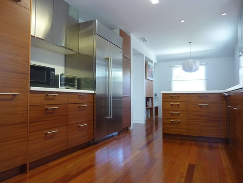 Contemporary kitchen with mahogany kitchen cabinets, stainless steel appliances and glossy hardwood flooring