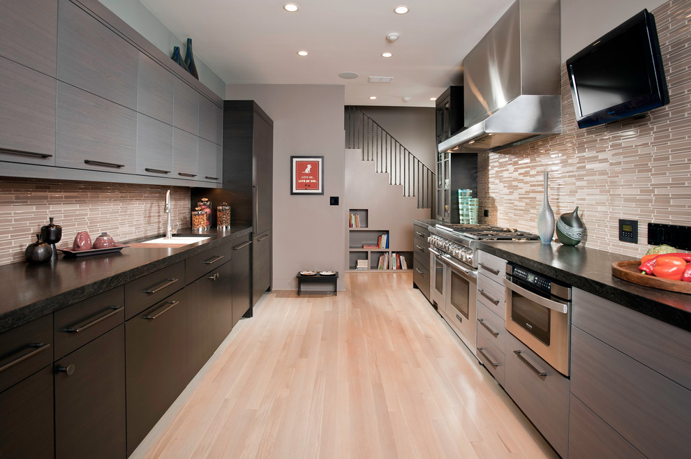 Design ideas for a large contemporary galley separate kitchen in Chicago with granite benchtops, stainless steel appliances, flat-panel cabinets, grey cabinets, brown splashback, matchstick tile splashback, an undermount sink, light hardwood floors, no island and beige floor.