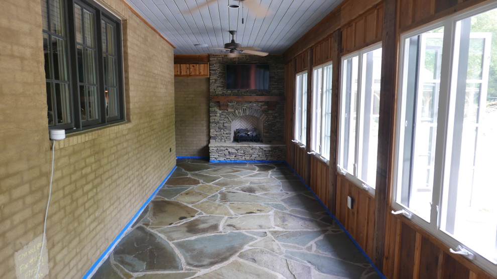 Immagine di una veranda stile americano di medie dimensioni con pavimento in pietra calcarea, camino classico, cornice del camino in pietra ricostruita, soffitto classico e pavimento multicolore