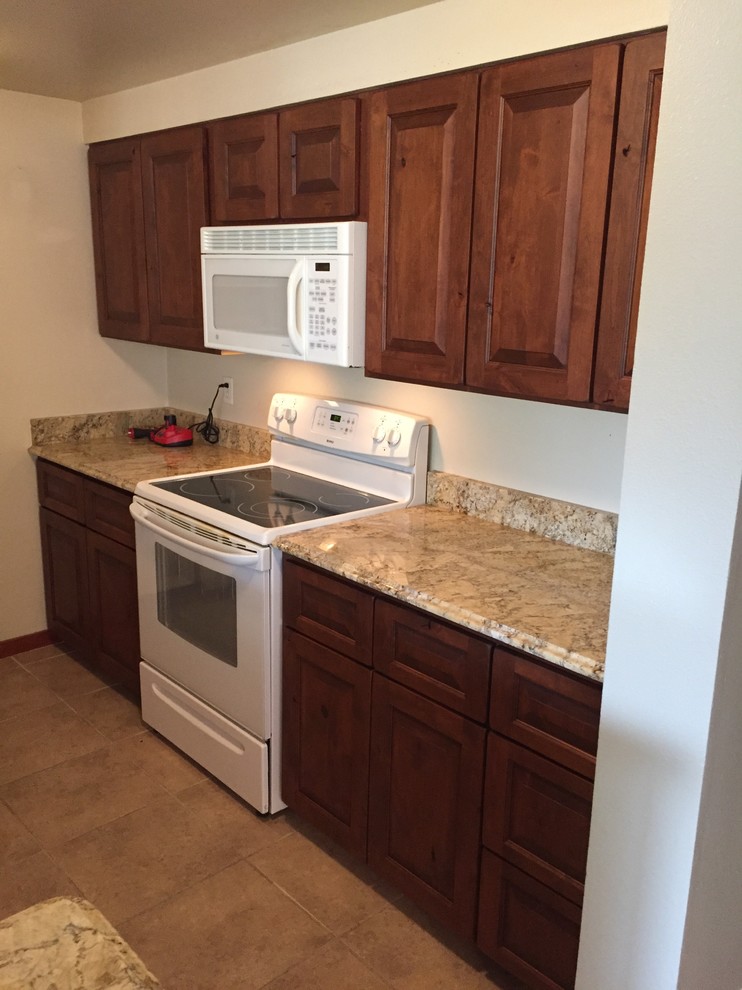 Example of a small mountain style u-shaped ceramic tile kitchen pantry design in Denver with an undermount sink, shaker cabinets, medium tone wood cabinets, granite countertops, beige backsplash, white appliances and no island