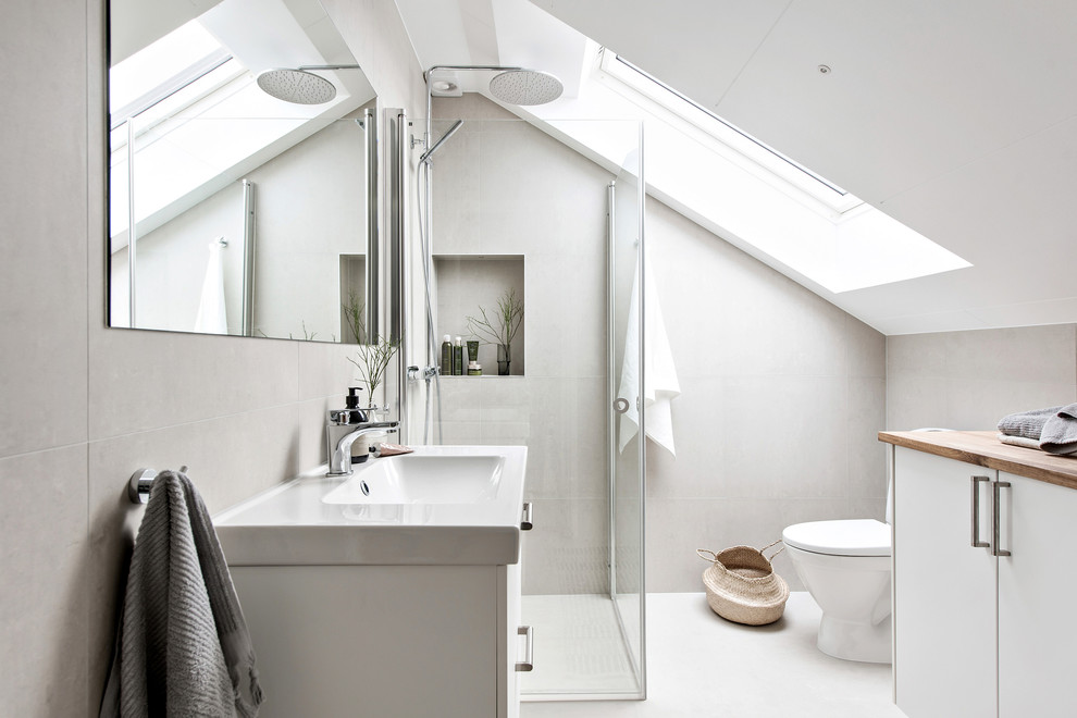 Design ideas for a mid-sized scandinavian 3/4 bathroom in Gothenburg with white cabinets, a corner shower, wood benchtops, white floor, a hinged shower door, flat-panel cabinets, gray tile and a console sink.