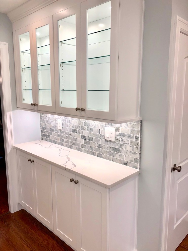 Inspiration for a mid-sized transitional u-shaped dark wood floor and brown floor enclosed kitchen remodel with an undermount sink, shaker cabinets, white cabinets, marble countertops, gray backsplash, stone tile backsplash, stainless steel appliances, no island and white countertops